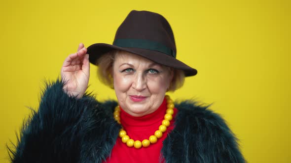 Closeup of Confident Flirty Senior Woman in Elegant Hat Looking at Camera Smiling