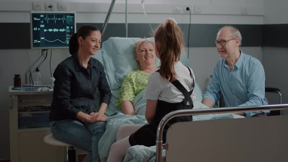 Child Talking to Senior Woman in Hospital Ward Bed Visiting Patient