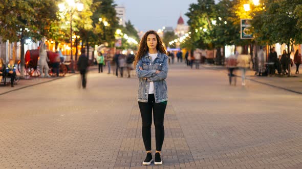 Time-lapse of Attractive Woman with Long Curly Hair Standing in the Street with Crossed Arms