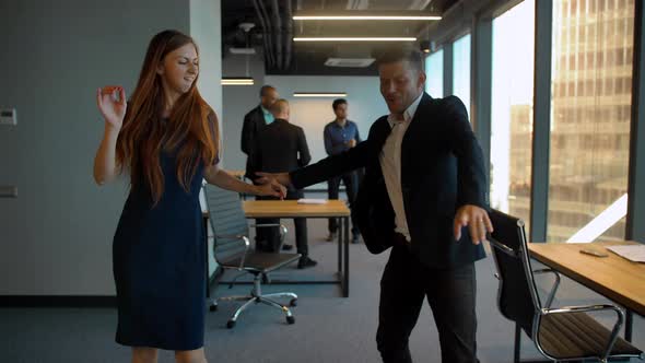 Couple in Business Office Dancing After Winning Deal Celebrating