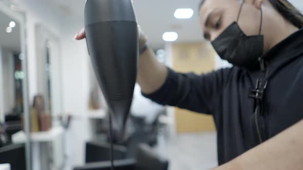 Gay Hispanic Hairstylist Giving a Service Using Hair Dryer in Slow Motion