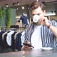 Young Adult Using Smartphone and Drink Coffee in Fashion Store - VideoHive Item for Sale