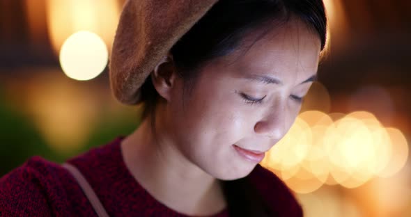 Woman use of mobile phone at outdoor coffee shop at night