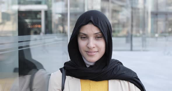 Attractive smiling woman wearing hijab and looking at camera