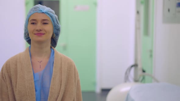 Portrait of Young Smiling Confident Caucasian Woman Walking in Hospital Corridor with Breast Marked