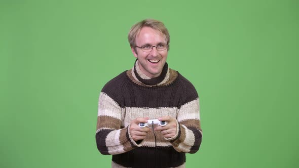 Studio Shot of Happy Handsome Man Playing Games and Winning