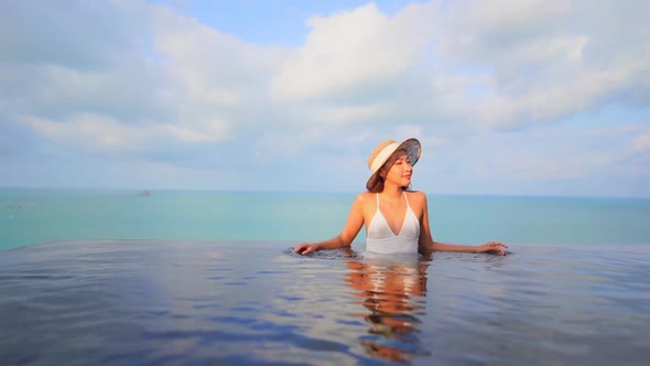 Young asian woman enjoy around outdoor swimming pool for leisure