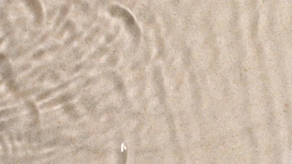 Slow Motion Closeup Water Surface Texture Splash and Ripples on Sand Background