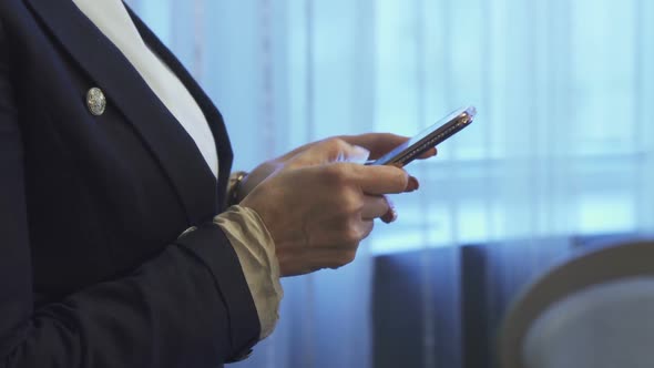 Business Woman Is Typing a Message on Her Mobile Phone