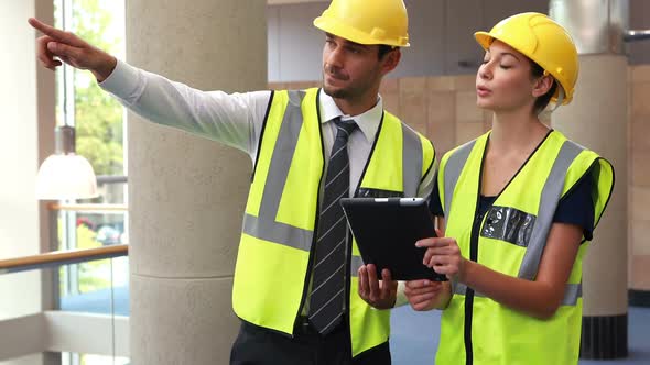 Architects discussing over digital tablet