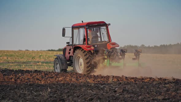 Tractor working in the field. Tractor cultivating and seeding a dry field