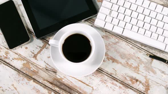 Digital tablet, smartphone, cup of tea, keyboard and mouse