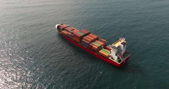 Container ship loaded with Shipping containers holding position at sea.