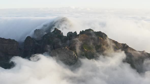 Aerial shot of a Mountain top with fasting clouds all around in Madeira, early morning