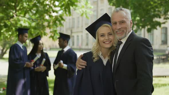 Female Graduate Hugging Dad and Smiling Into Camera, Successful Future, Career