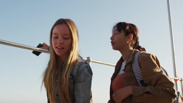 Side view of a Caucasian and a mixed race girl hanging out together