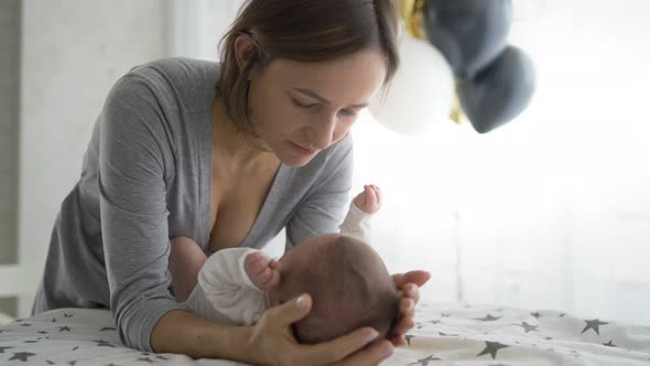 Beautiful Young Mother with a Baby Girl at Home