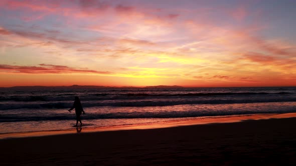 A enjoys her vacation at the beach during a gorgeous yellow, orange, pink and blue sunset with the H