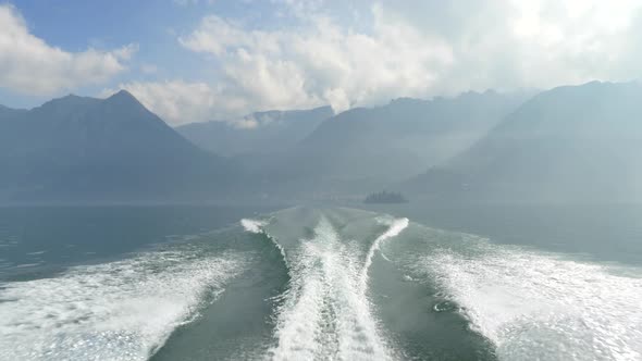 The wake from a classic luxury wooden runabout boat on an Italian lake.