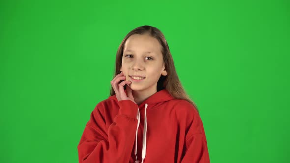 Portrait of Happy Girl in Red Jacket Posing Playfully on Green Screen.