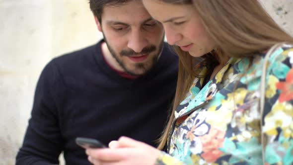 Couple looking at smartphone and laughing together