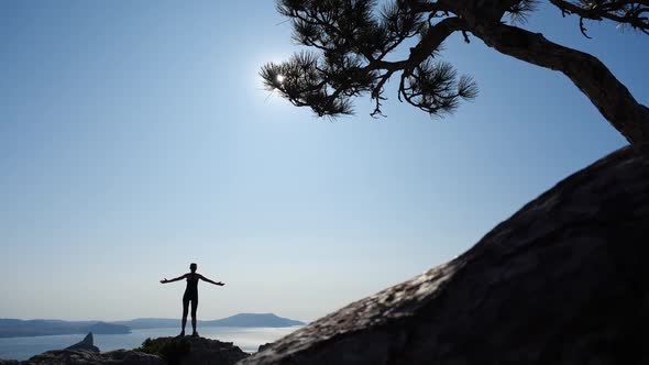 Athlete Woman Conquered a High Mountain Karaul-Oba and Enjoys a Beautiful View of the Sun and Black