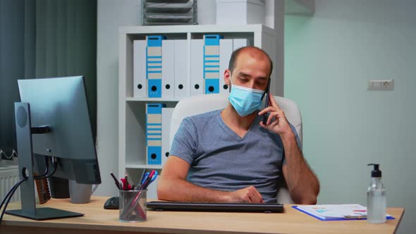 Freelancer with Mask Talking on Mobile Phone