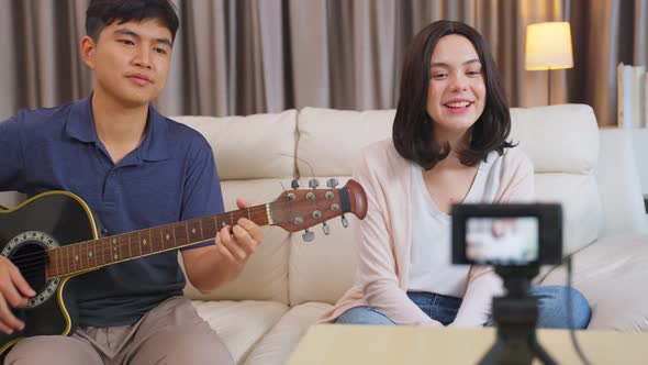 Young influencers sing a song and playing guitar, showing on live streaming or online broadcasting.