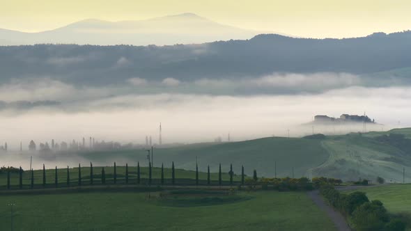 Tuscany Countryside with Rolling Hills in Morning Fog. Pienza, Val d'Orcia, Italy. Panning Shot