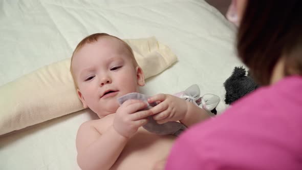 The masseuse gives a tummy massage to baby (boy) 20