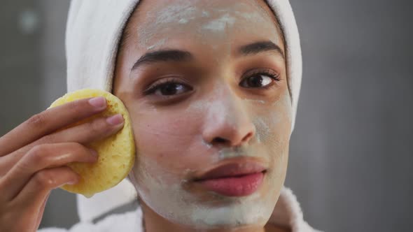 Close up of mixed race woman applying face mask in bathroom