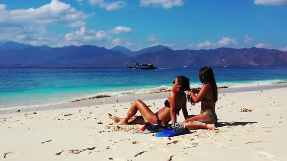 Women happy and smiling on exotic lagoon beach voyage by blue sea and white sandy background of Gili
