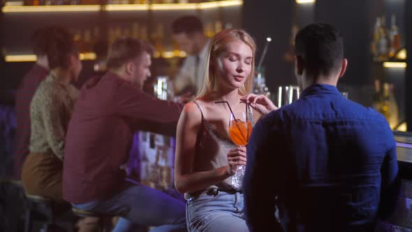 Attractive Woman Chatting with Man in Nightclub