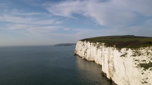 Aerial forward ascending along white wall of Old Harry Rocks cliff, Dorset in England