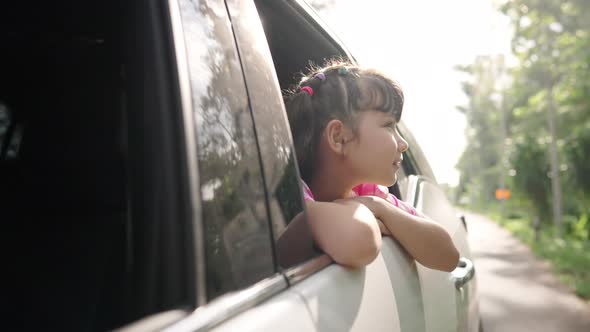 4K Happy little Asian girl enjoy and fun with family in the car on summer road trip vacation.