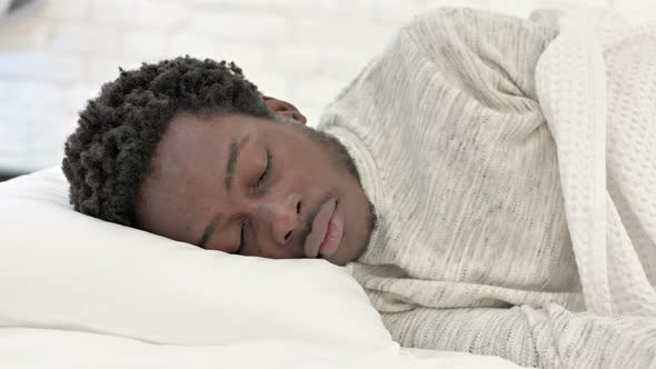 Happy African Man Sleeping in Bed