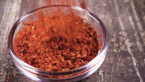 Slow Motion Ground Paprika Pour Into a Bowl Close Up