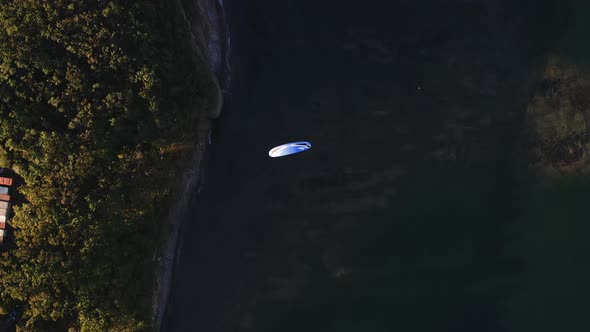 Aerial View of a Paraglider with an Engine Flying By the Coast of the Sea