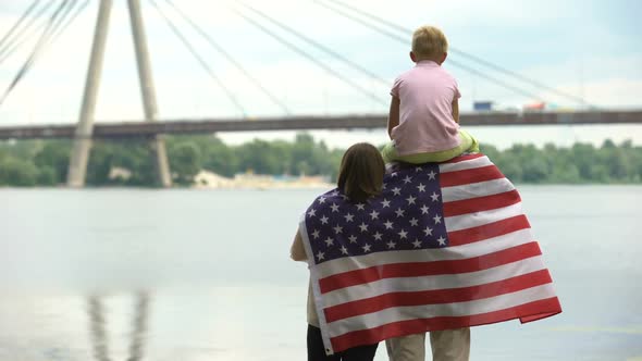 Family Wrapped in American Flag Looking at Bridge, Immigration, Independence Day