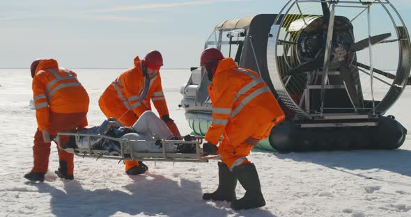 Lifesavers Reanimating Victim on Stretchers in Arctic on Frozen Ocean