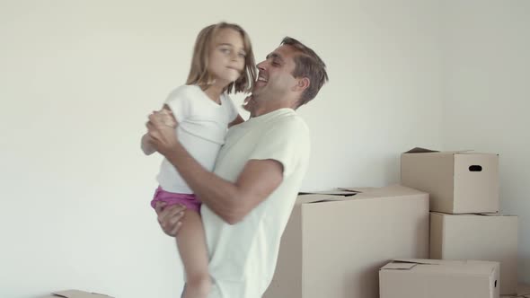 Joyful Dad Holding Daughter in Arms and Dancing