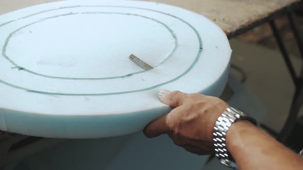 Closeup Hand Male Worker Cutting Foam Rubber for the Production of a Sofa in a Furniture Factory