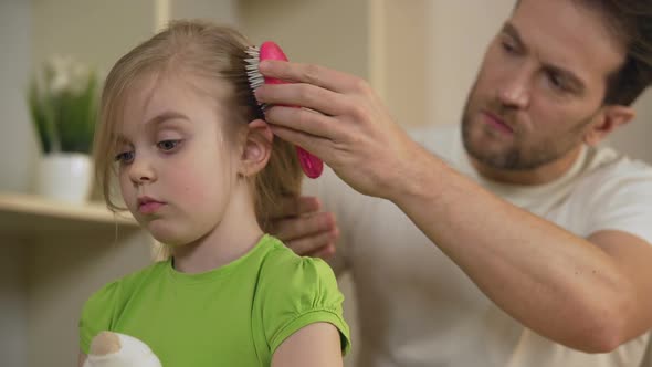 Strict Father Combing Sad Little Daughter's Hair With Serious Face, Home Tyrant