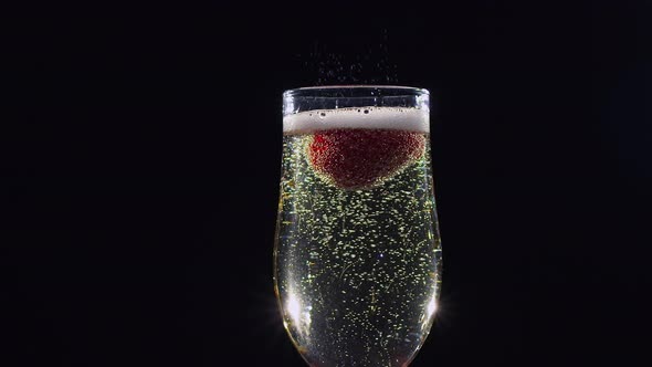 Mellow Strawberry in Glass with Champagne Sparkling Wine. Slow Motion