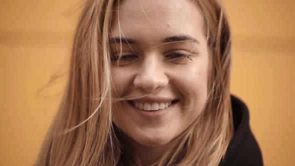 Headshot of Gorgeous Young Woman with Straight Blond Hair Smiling Being Positive During Her Walk