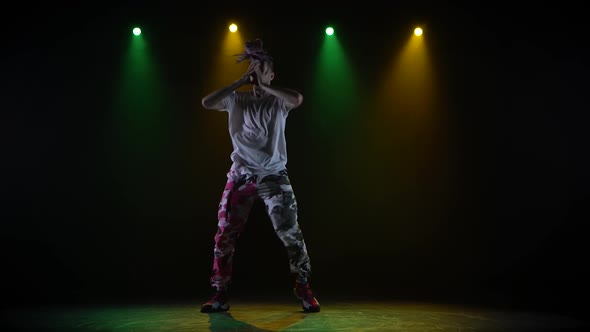 Professional Young Hip-hop Dancer, Dancing in Dark Studio in the Green and Yellow Fog. Hip Hop