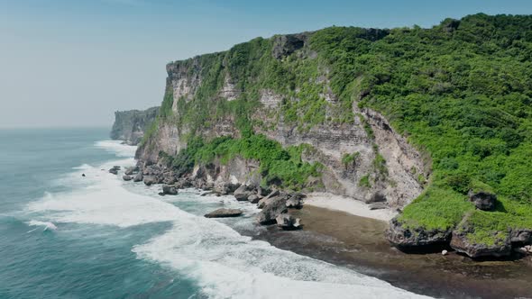 Beautiful Aerial View of High Cliffs with Green Trees and Bushes Above Roaring Ocean