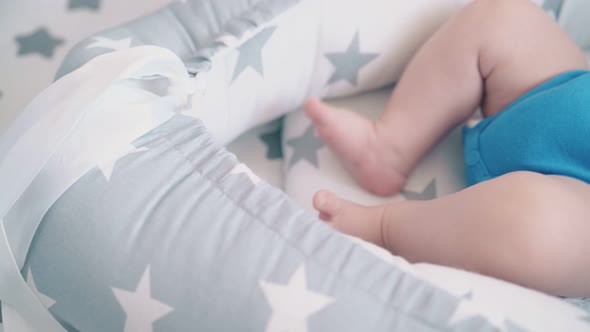 Cute Kid with Bare Legs Rests in Cocoon with Star Patterns