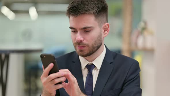 Upset Young Businessman Having Loss on Smartphone 