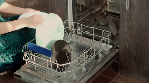 Housewife Uses Modern Appliance To Keep Clean Kitchen. Loading Dirty Plates Kitchenware.